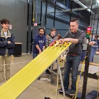 Students look on as vehicles get ready to race